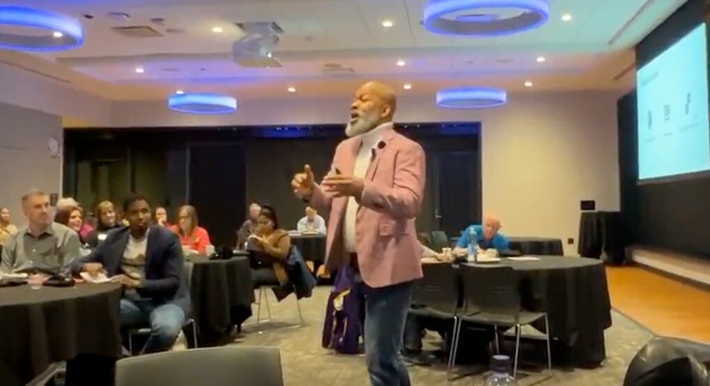 Robert in a pink blazer leading a workshop