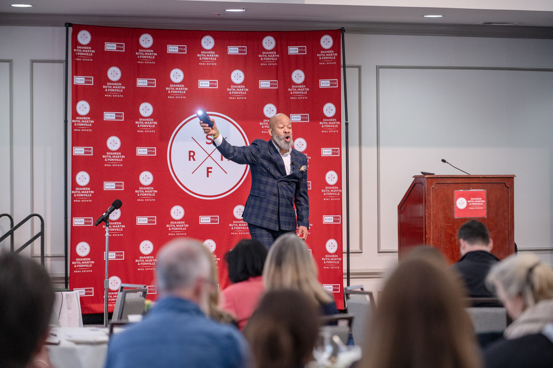 Robert on stage in front of a red event backdrop